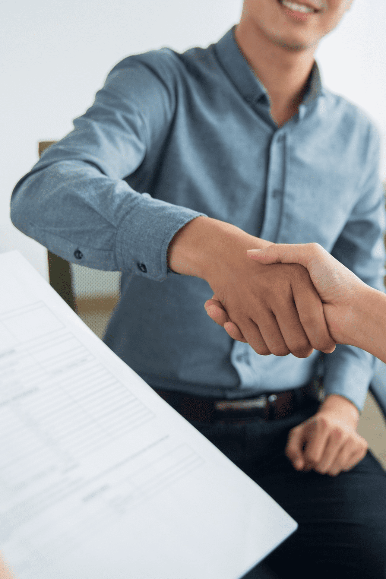 Smiling Asian businessman shaking partners hand Business Insurance